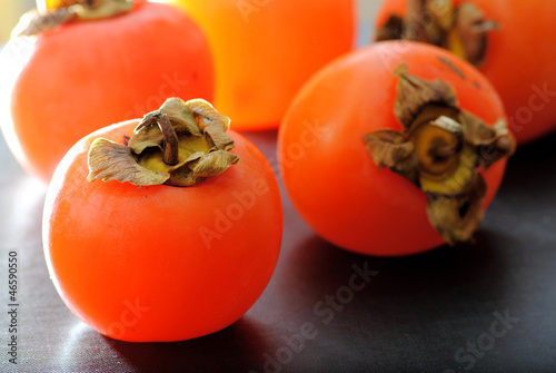 Close up fuyu persimmons fruits on black background