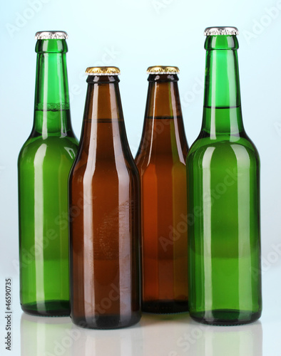 Coloured glass beer bottles on blue background