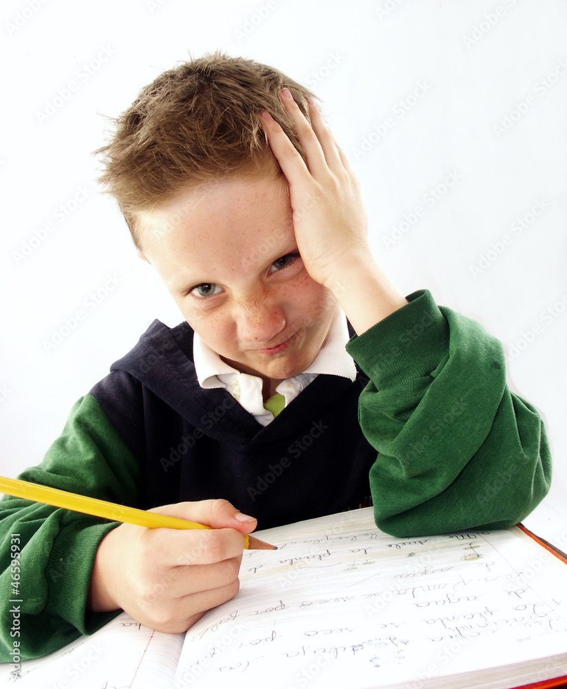 Niño estudiando, escribiendo,sentado en un pupitre.escolar. ภาพถ่าย ...