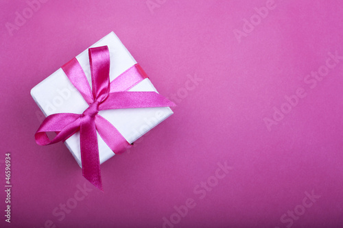 gift box with pink ribbon on pink background