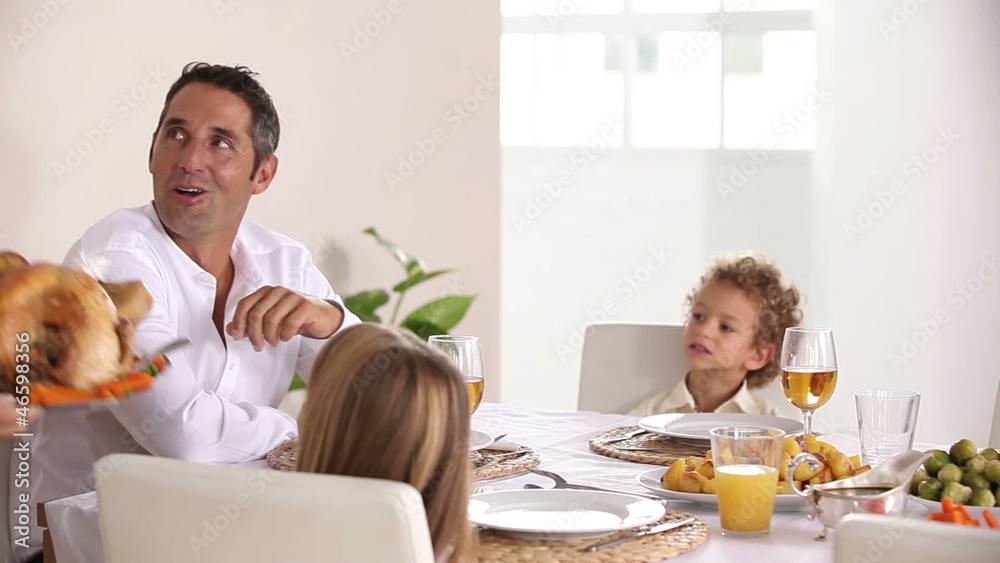 Mother bringing turkey to dinner table at family dinner Mother bringing turkey to dinner table at family dinner