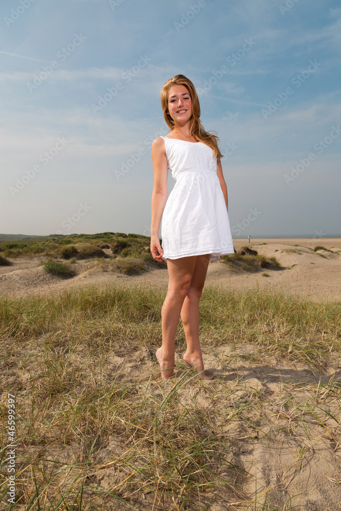 Pretty girl red long hair wearing white dress enjoying outdoors.