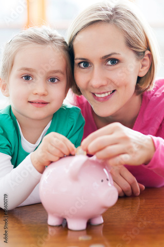 Mother and daughter with piggy bank