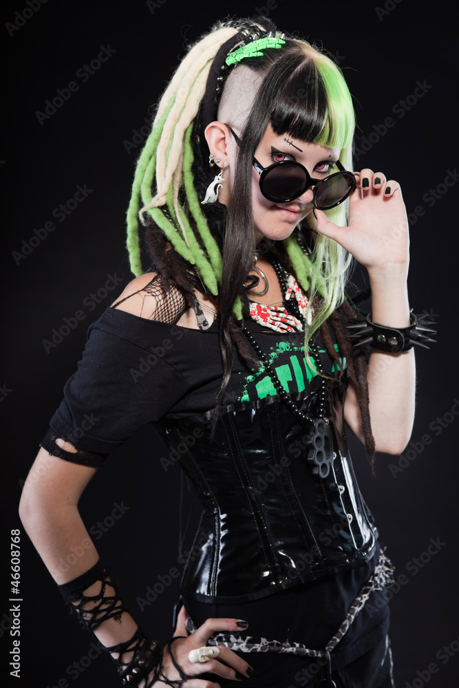 Cyber punk girl with green blond hair and red eyes against black