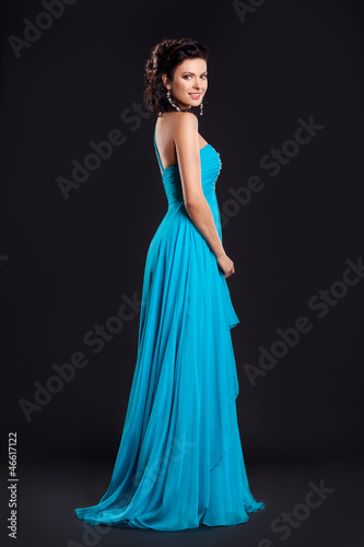 Fashion young woman in funky blue long dress smiling