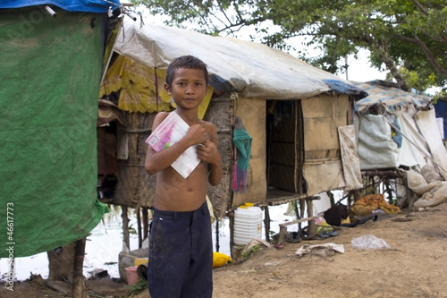 Boy in slum holding book want to go school