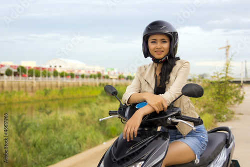 sexy asian girl with mini skirt, helmet, motorcycle in cambodia