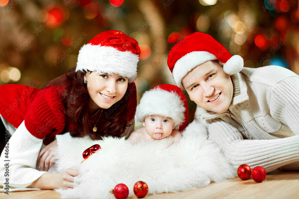 Christmas family in red hats. Happy parents and baby Christmas family in red hats. Happy parents and baby