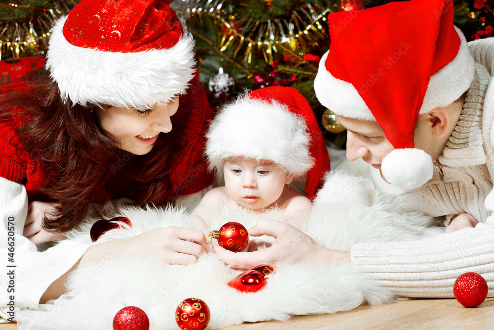 Christmas family with baby in red hats giving gifts Christmas family with baby in red hats giving gifts