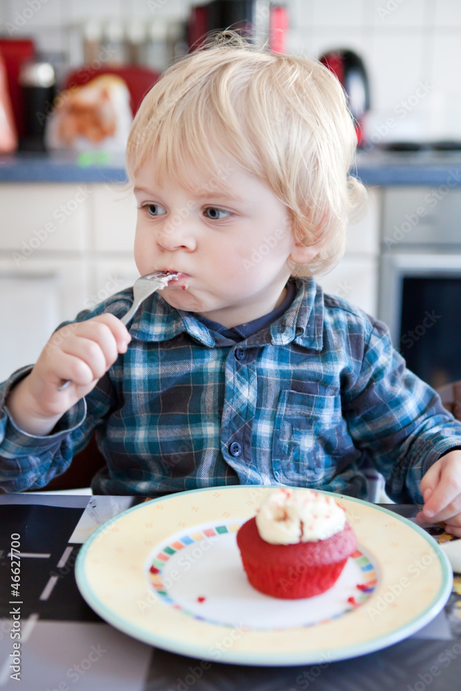 Little boy eating red cupcake Little boy eating red cupcake