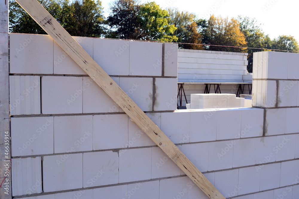 Obraz premium Bau einer Kalksandsteinmauer mit Richtscheit