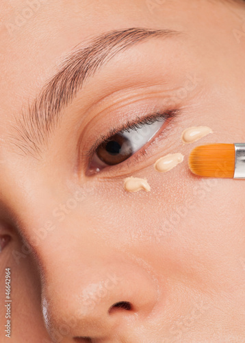 Woman applying foundation photo