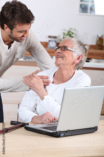 man explaining to senior woman how to use computer