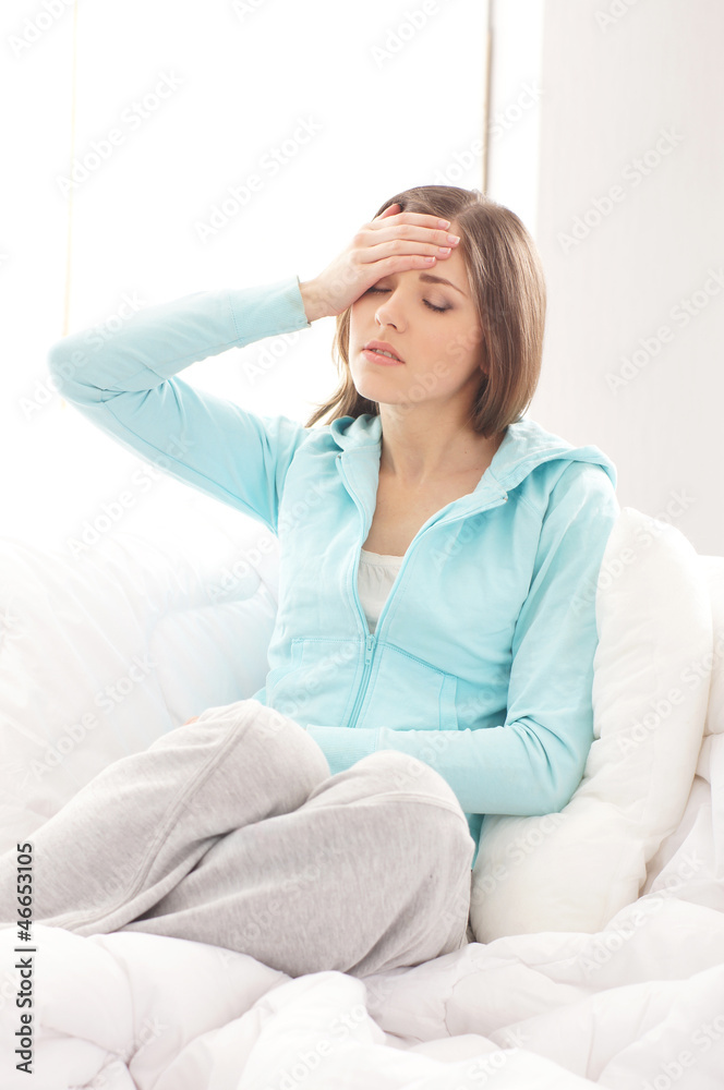 A young brunette woman suffering from pain in her head A young brunette woman suffering from pain in her head