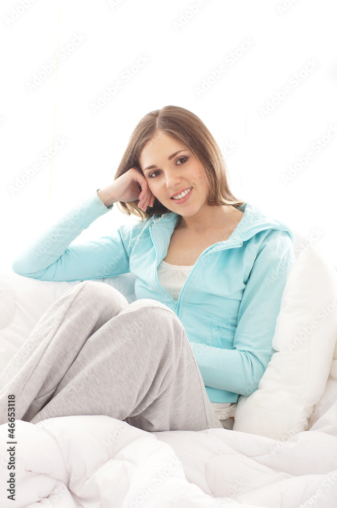 Portrait of a young and happy brunette sitting in the bed Portrait of a young and happy brunette sitting in the bed