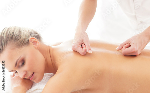A young blond woman relaxing on a spa massage procedure