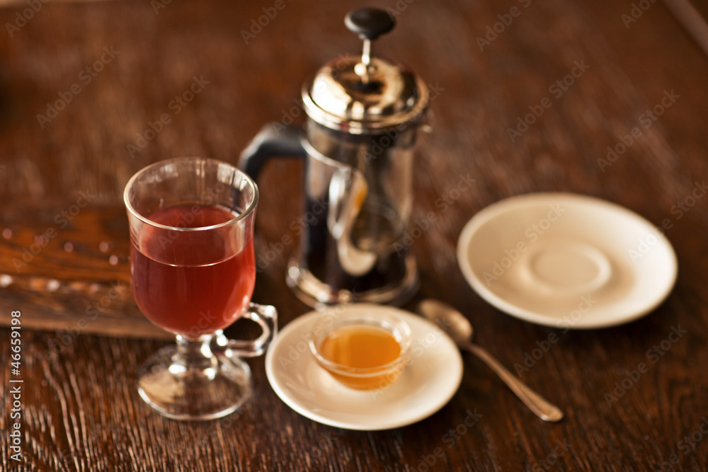 red tea with honey on wood table.