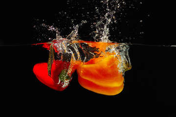 Deken met foto Opspattend water Red and yellow bellpepper falling into the water with a splash  © Boris Bulychev