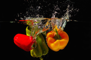 Deken met foto Opspattend water Red, green and yellow bellpepper falling into the water  © Boris Bulychev