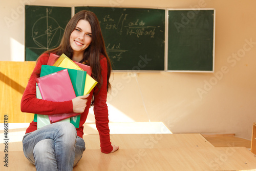 beautiful teen girl high achiever in classroom near desk happy s photo