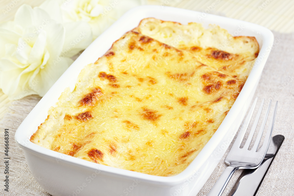 Kannelloni with chicken and mushrooms baked in sauce bechamel