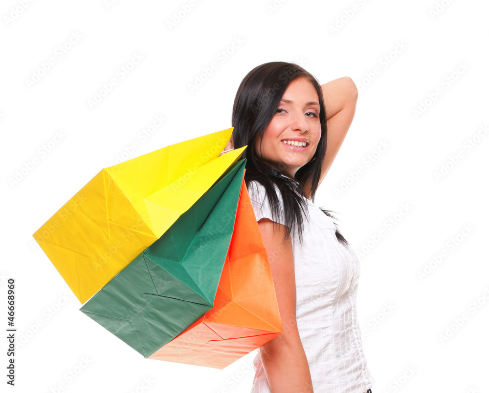 Portrait of young woman carrying shopping bags against white bac Portrait of young woman carrying shopping bags against white bac