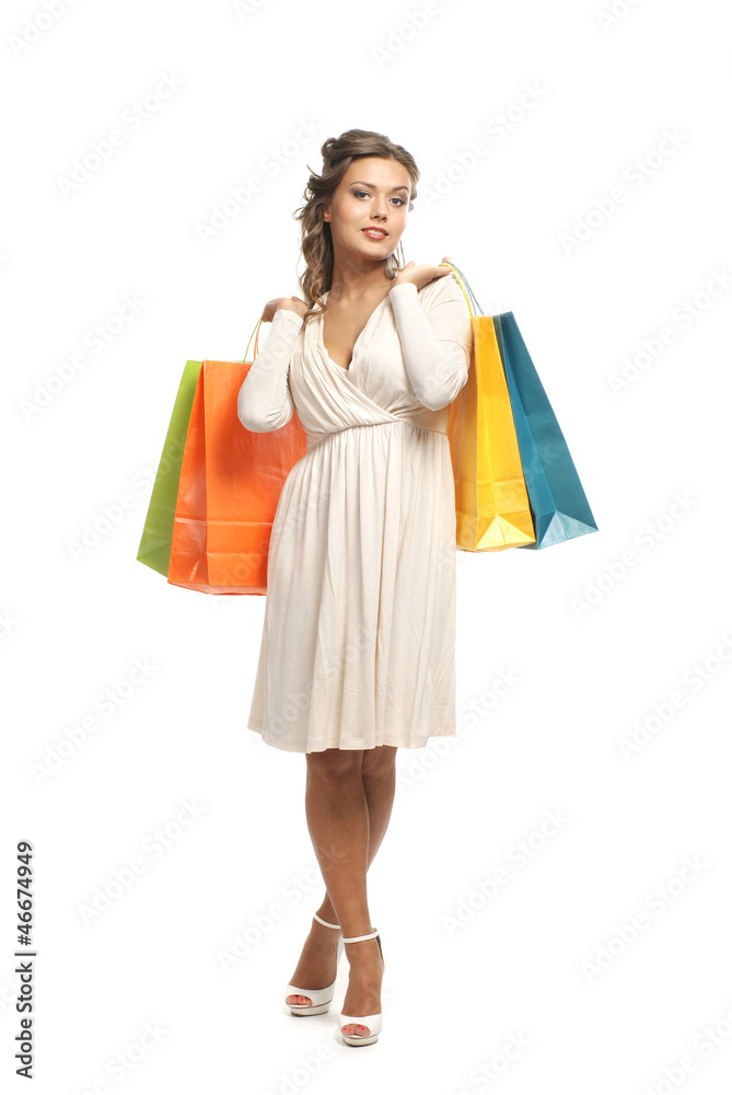 A young woman in a white dress holding shopping bags