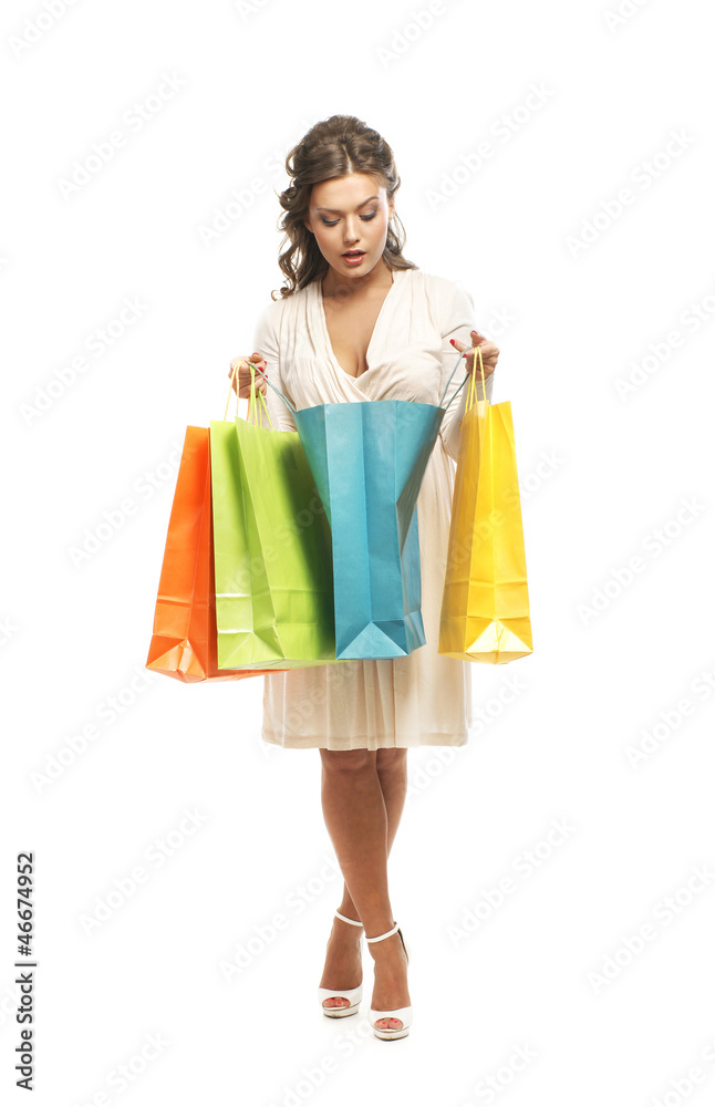 A young woman in a white dress opening a shopping bag