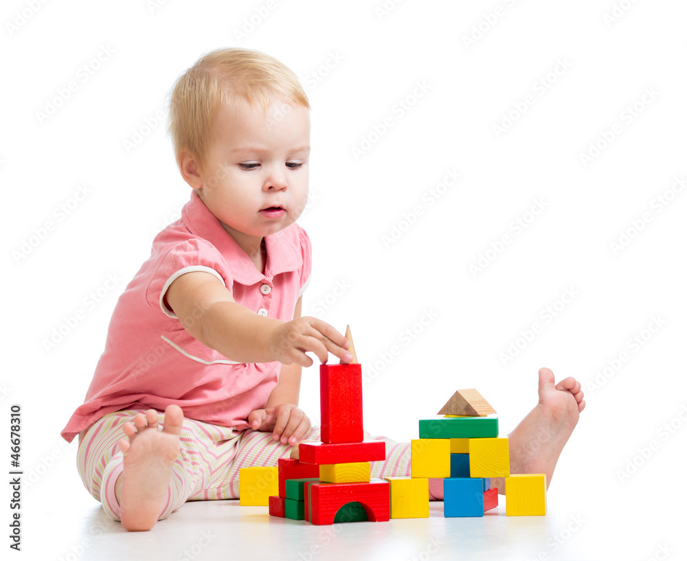 Child girl playing toy blocks and building tower. Isolated on wh Child girl playing toy blocks and building tower. Isolated on wh