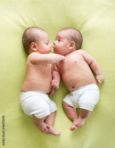 Canvastavla funny twins brothers babies lying on green