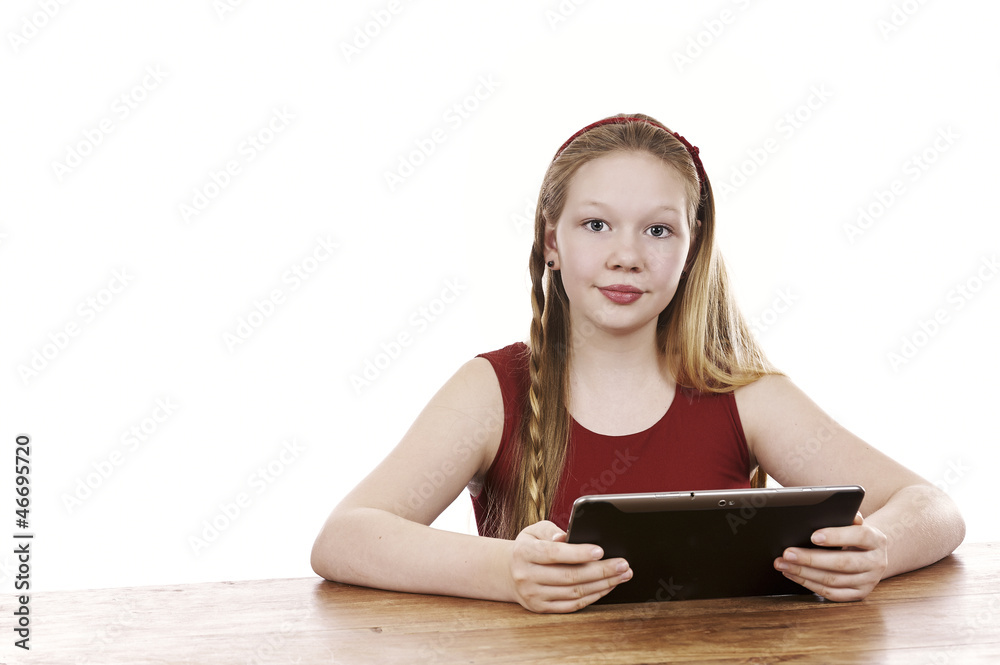 Beautiful young girl sitting by table with tablet computer Beautiful young girl sitting by table with tablet computer