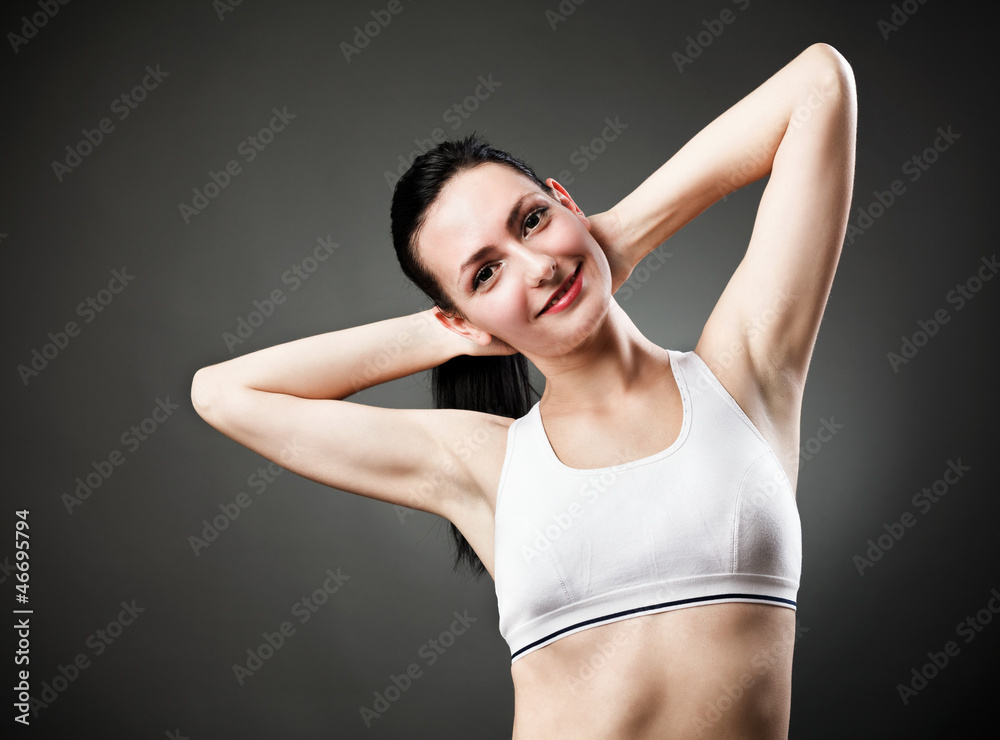 Beautiful sporty woman stretching her body