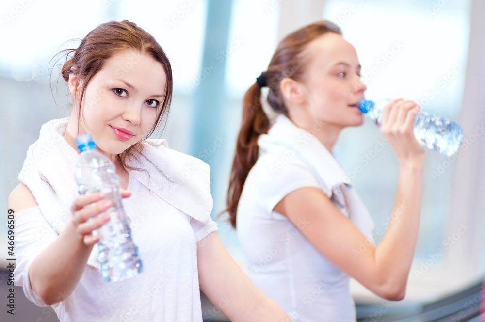 Women drinking water after sports Women drinking water after sports