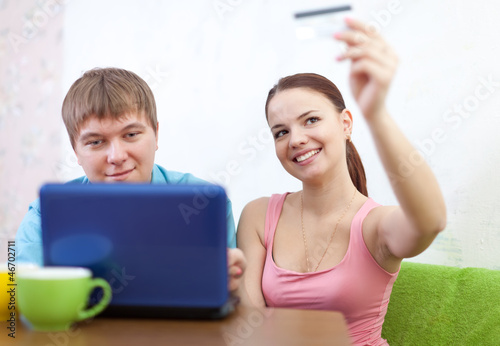 Smiling couple shopping online at home
