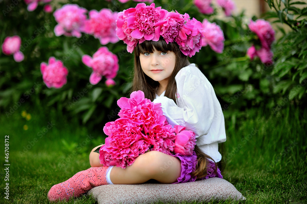 Fototapeta premium portrait of little girl outdoors with peony