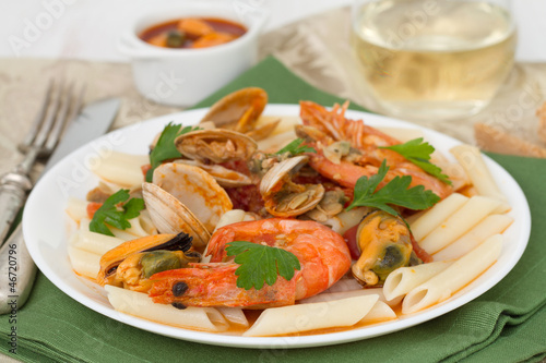penne with shrimps, mussels and parsley on the plate