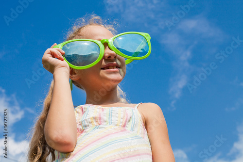 girl in big sunglasses looking at the sky
