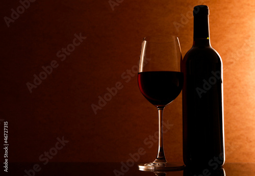 Bottle and Glass with red whine on the table
