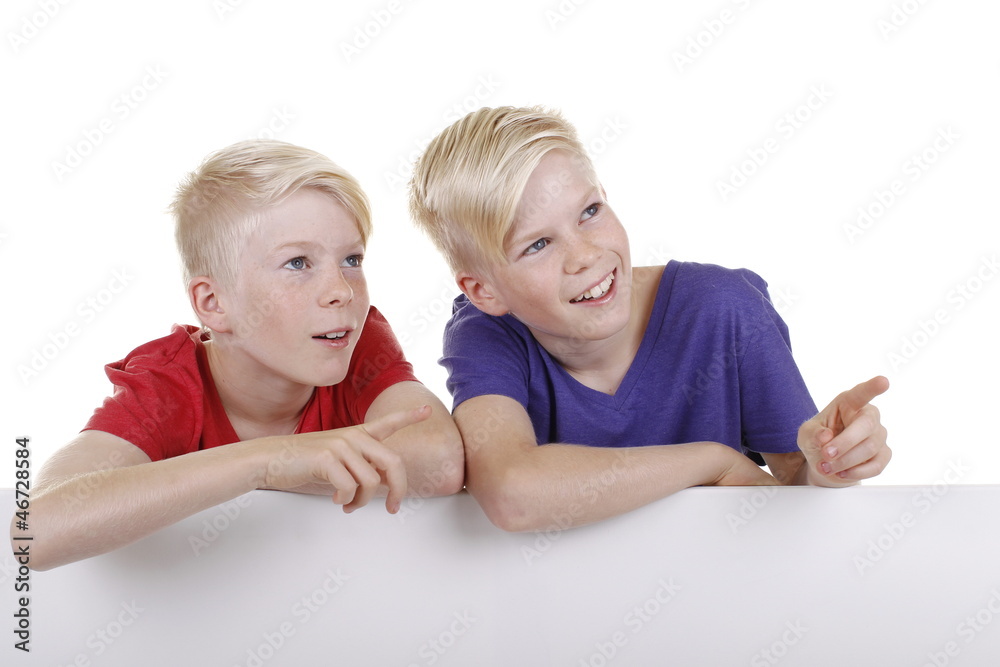 Zwei blonde Zwillinge zeigen nach oben Zwei blonde Zwillinge zeigen nach oben