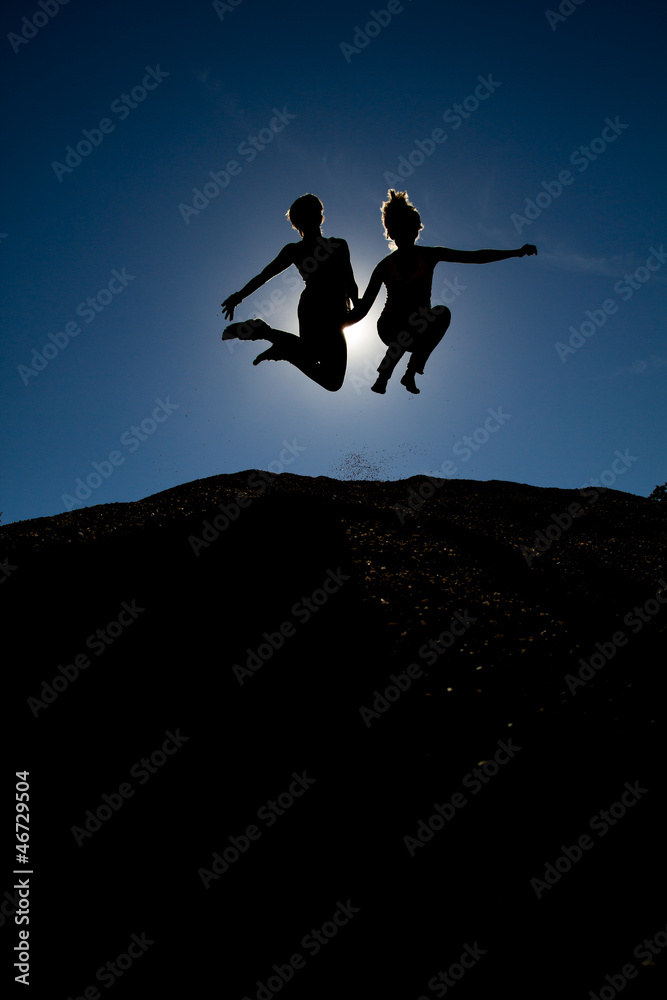 silhouette of couple jumping on top of hill silhouette of couple jumping on top of hill