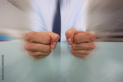 Businessman banging his fists on his desk