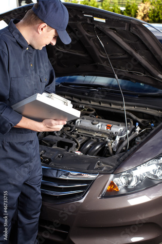 Car mechanic working in auto repair service.