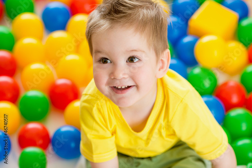 Cute kid or child playing colorful balls top view
