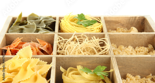 Nine types of pasta in wooden box sections close-up isolated