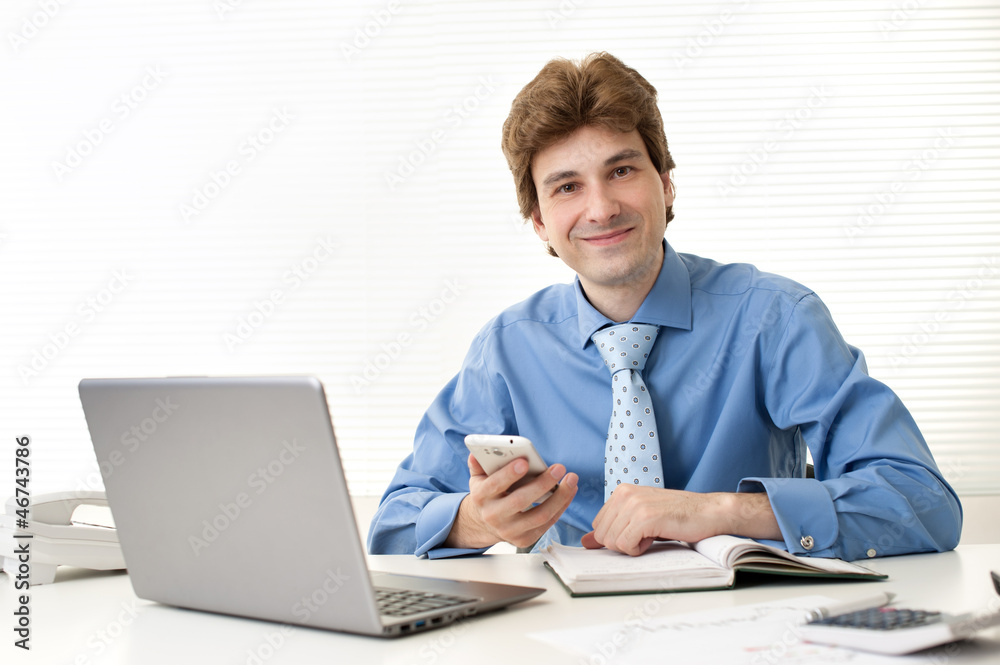Businessman sitting at office desk working on laptop computer Businessman sitting at office desk working on laptop computer