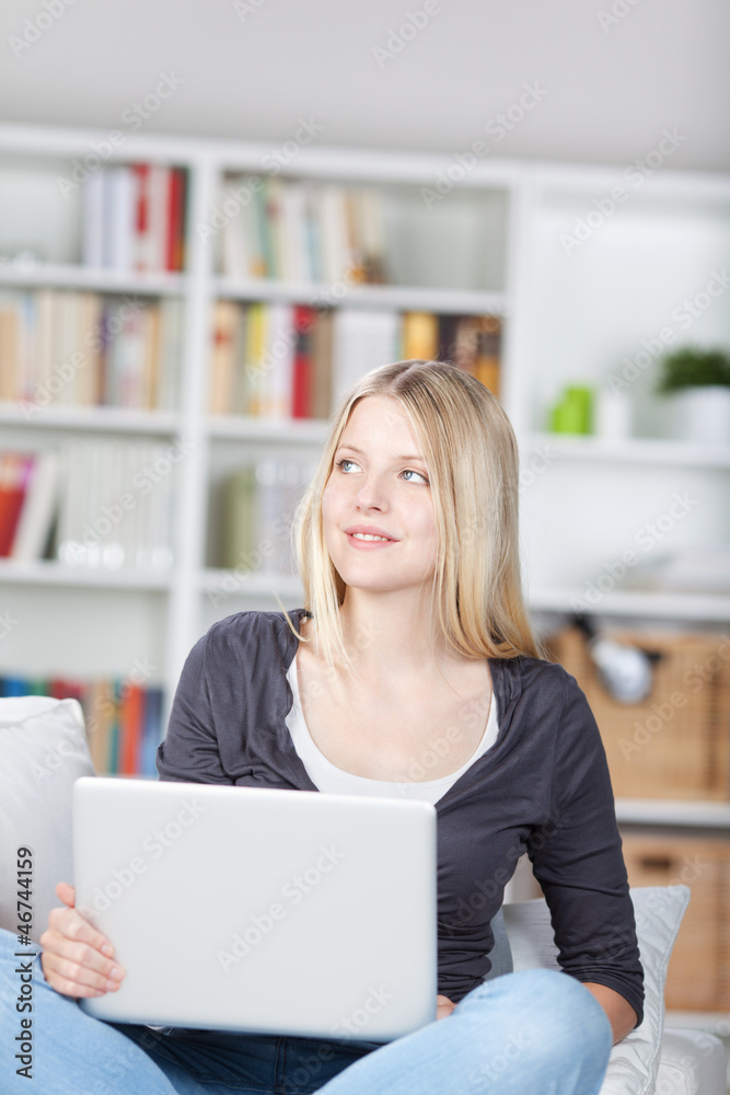 blonde frau sitzt mit laptop auf dem sofa blonde frau sitzt mit laptop auf dem sofa