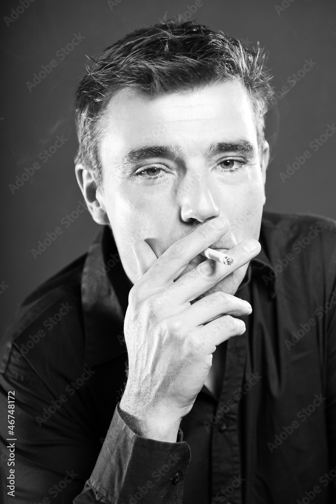 Smoking man with short brown hair. Black and white studio shot. Smoking man with short brown hair. Black and white studio shot.