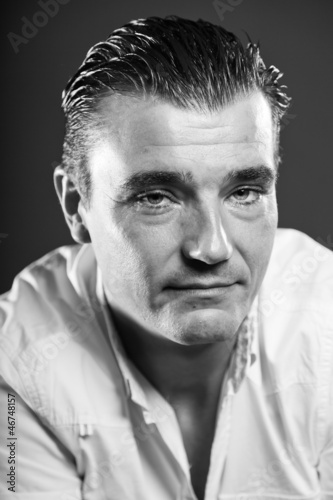 Handsome man with short brown hair. Black and white studio.