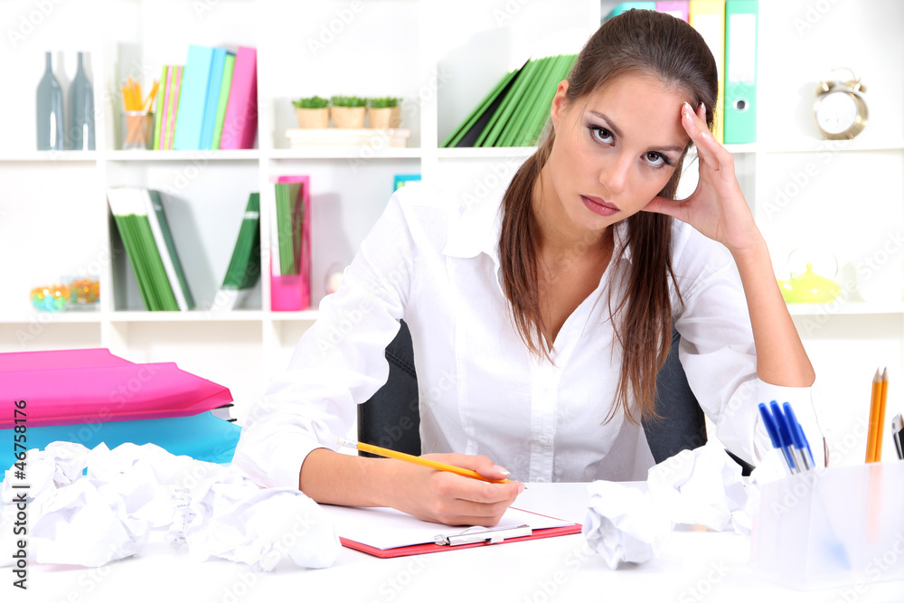 Thoughtful business woman with documents in office