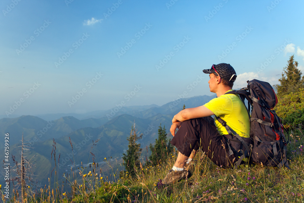 young man in the mountains at sunset